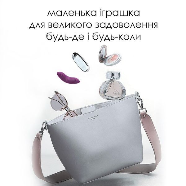 Міні-вібратор Svakom Edeny поруч із жіночими аксесуарами у сумочці